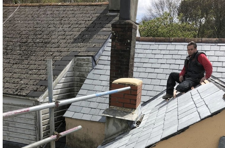 NAC Roofing working on a roof repair near a chimney